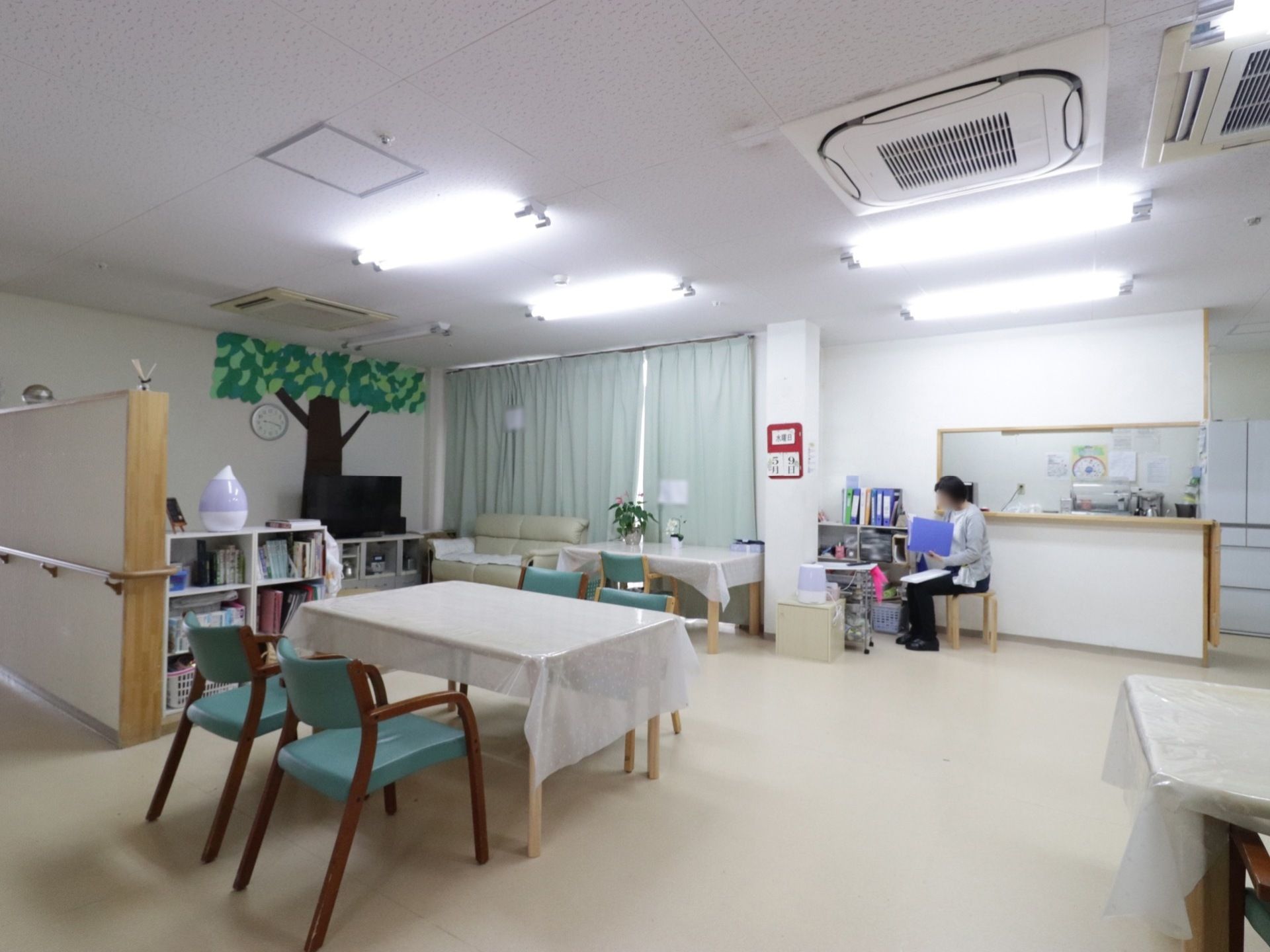 通路が広く車椅子をご利用の方も快適に過ごせるようにテーブルが配置されている。スタッフが居るので安心して過ごせる。