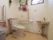 洗面台が備わった広々としたトイレである。壁には、可動式やL型手すり、呼び出しボタンが設置されている。