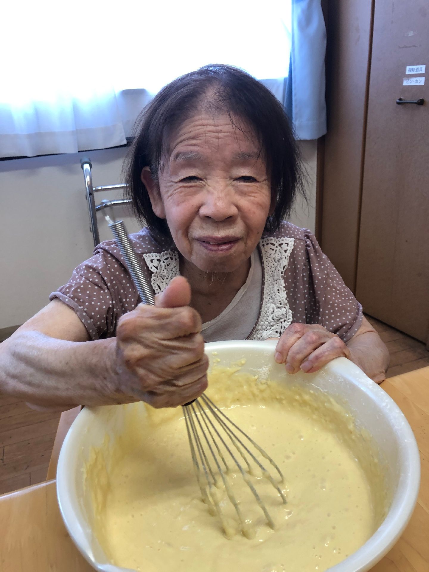 女性スタッフと一緒にテーブルを囲んで食事を採っている入居者様達
