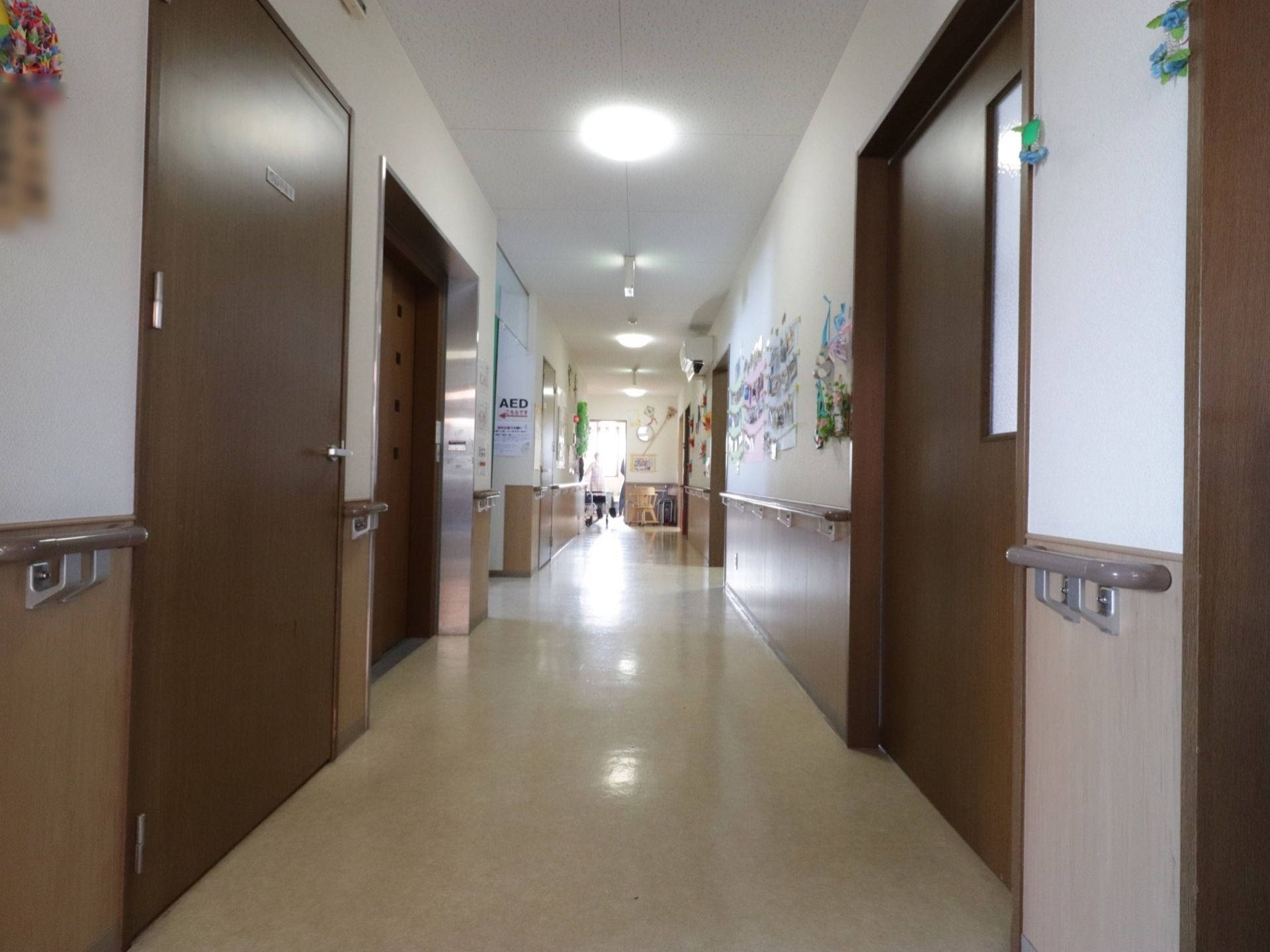広々とした明るい廊下である。両側の壁には手すりが完備されている。AEDが設置されているので安心である。