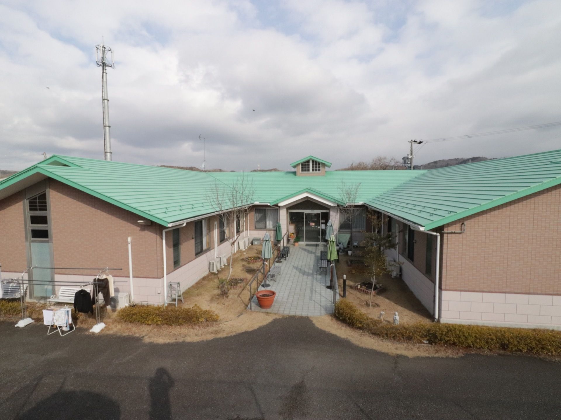 施設は、緑の屋根の平屋建ての建物である。コの字型になっており、真ん中にエントランスがある。建物前に洗濯物干し台が設置されている。
