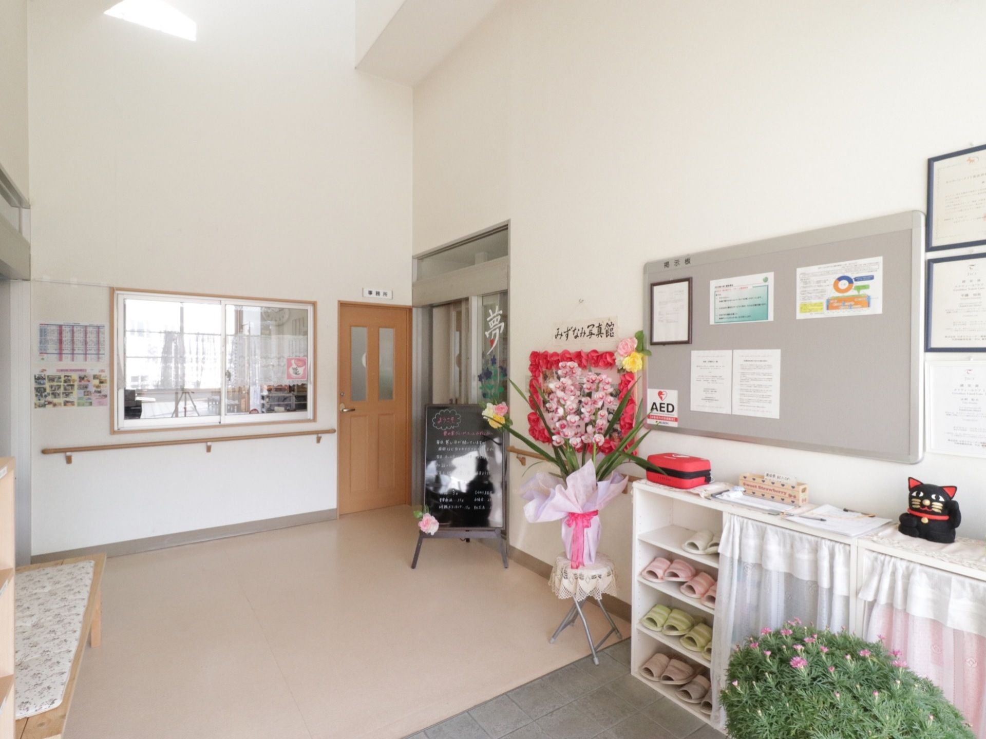 広々とした玄関ホールには、ベンチやスリッパが置かれた靴箱が壁際に設置されている。胡蝶蘭が飾られている。