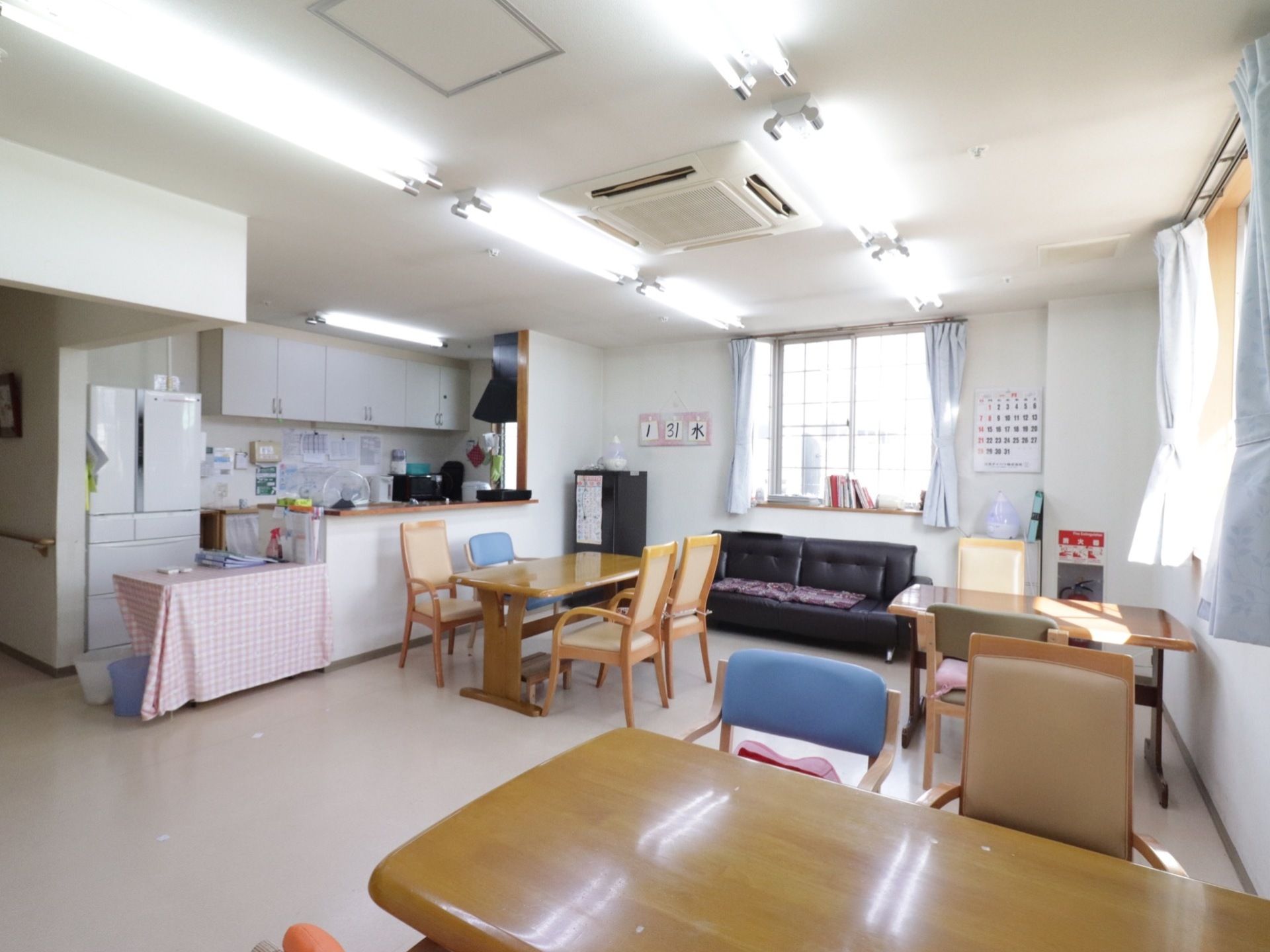 入居者様が集まる十分な広さが確保された食堂である。対面式キッチンが設けられており、ソファやダイニングテーブルが配置されている。