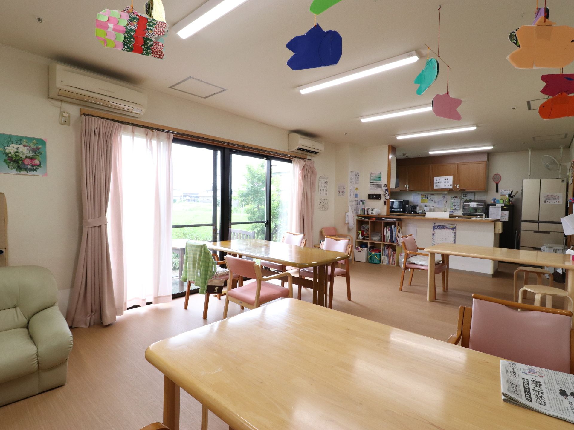 エアコンが2台設置されている。大きな窓があり、とても明るい空間である。キッチンがある。テーブルや椅子があり、ゆっくり過ごすことができる。