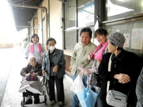 ひさしの下に集まっている入居者様と２名の女性スタッフ