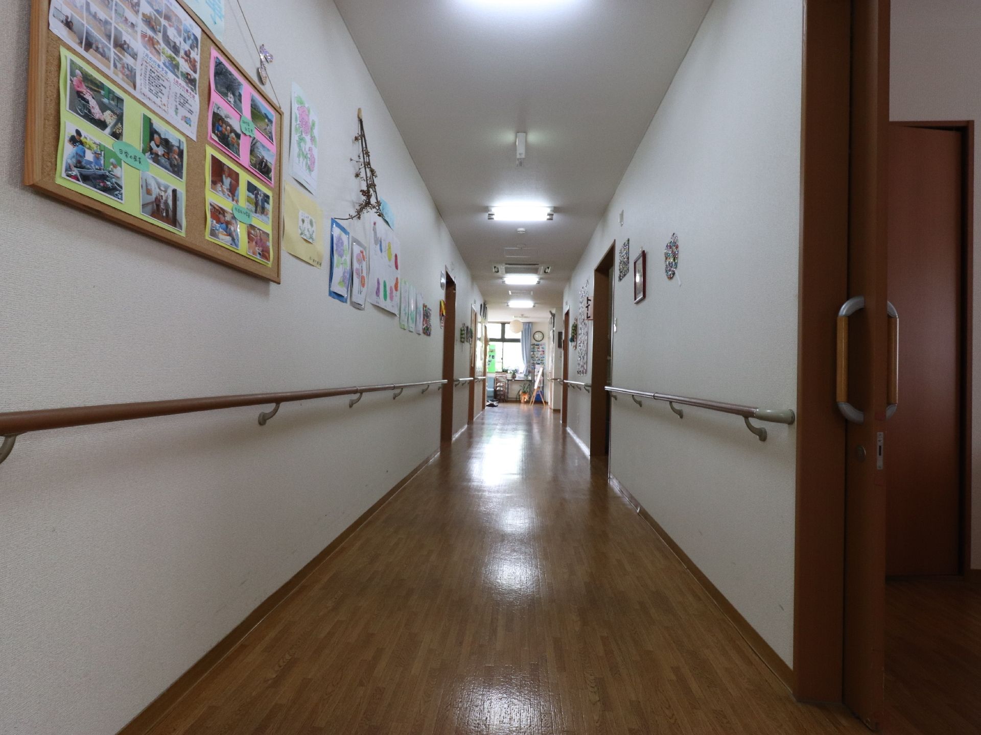 長い廊下には手すりが両サイドに設置されている。壁にはたくさんの思い出の写真などが飾ってあり、明るい雰囲気になっている。