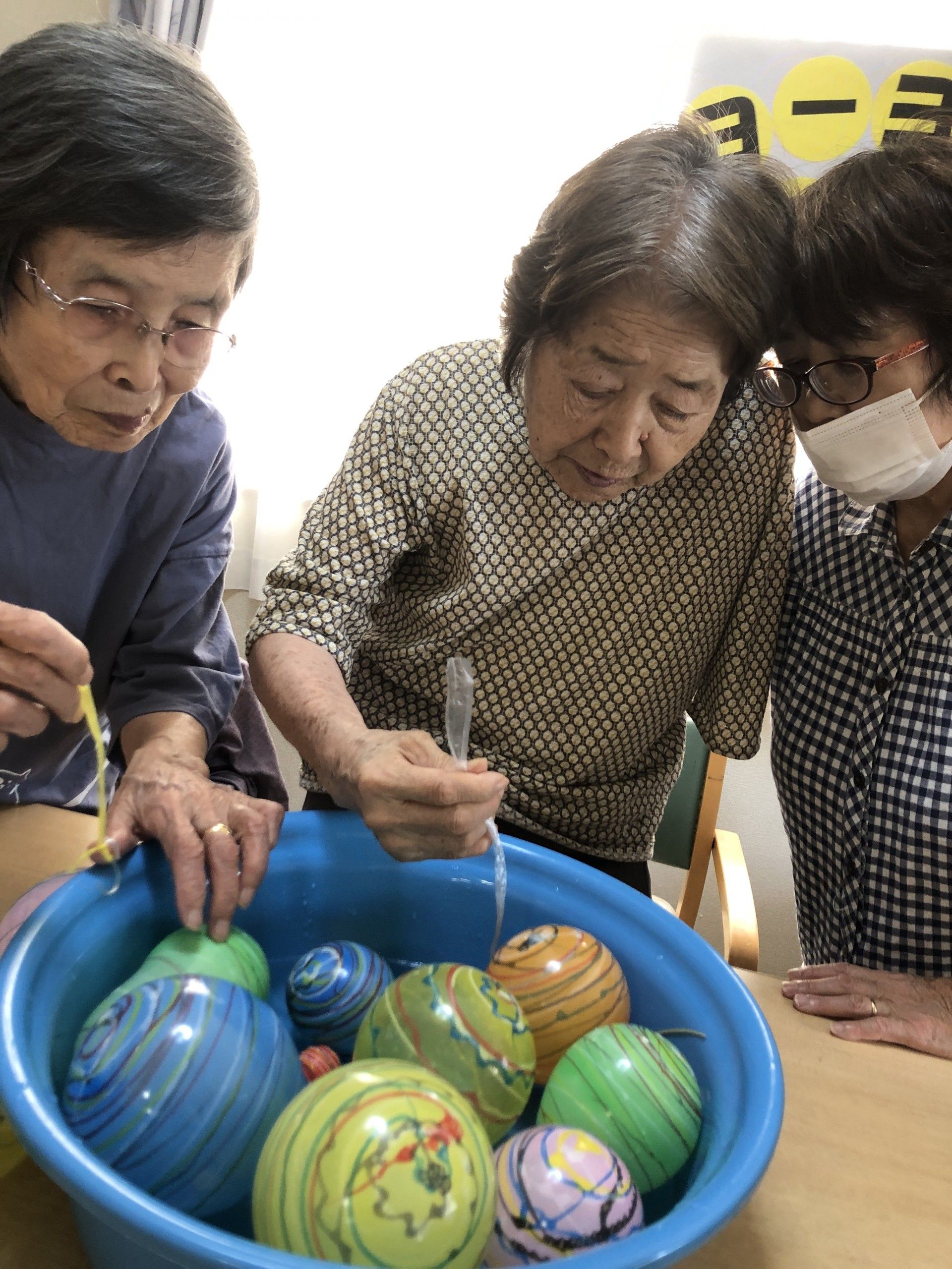 色とりどりの花が飾られているテーブルについている２名の女性入居者様