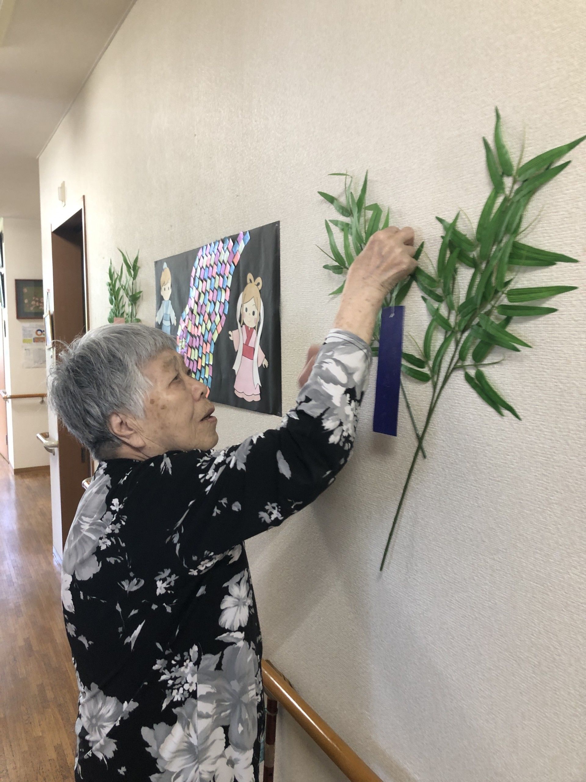 キッチン近くのテーブルで野菜の筋取りをしている２名の女性入居者様