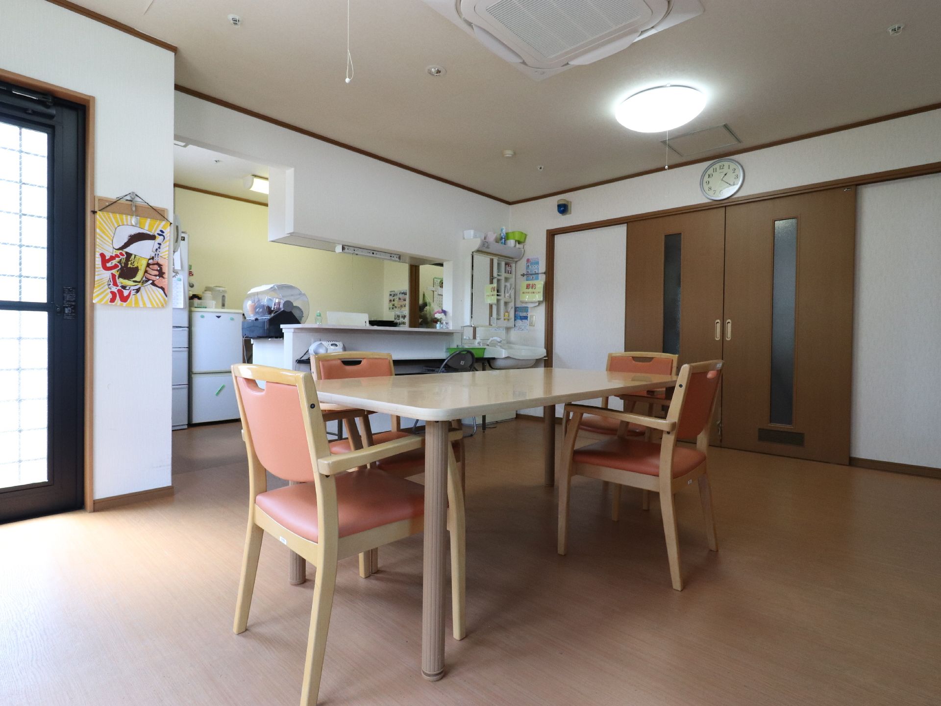 ダイニングの入り口のドアは引き戸式で幅が広い。部屋の角に洗面台が設置されている。スタッフと声を掛けやすいのが特徴。