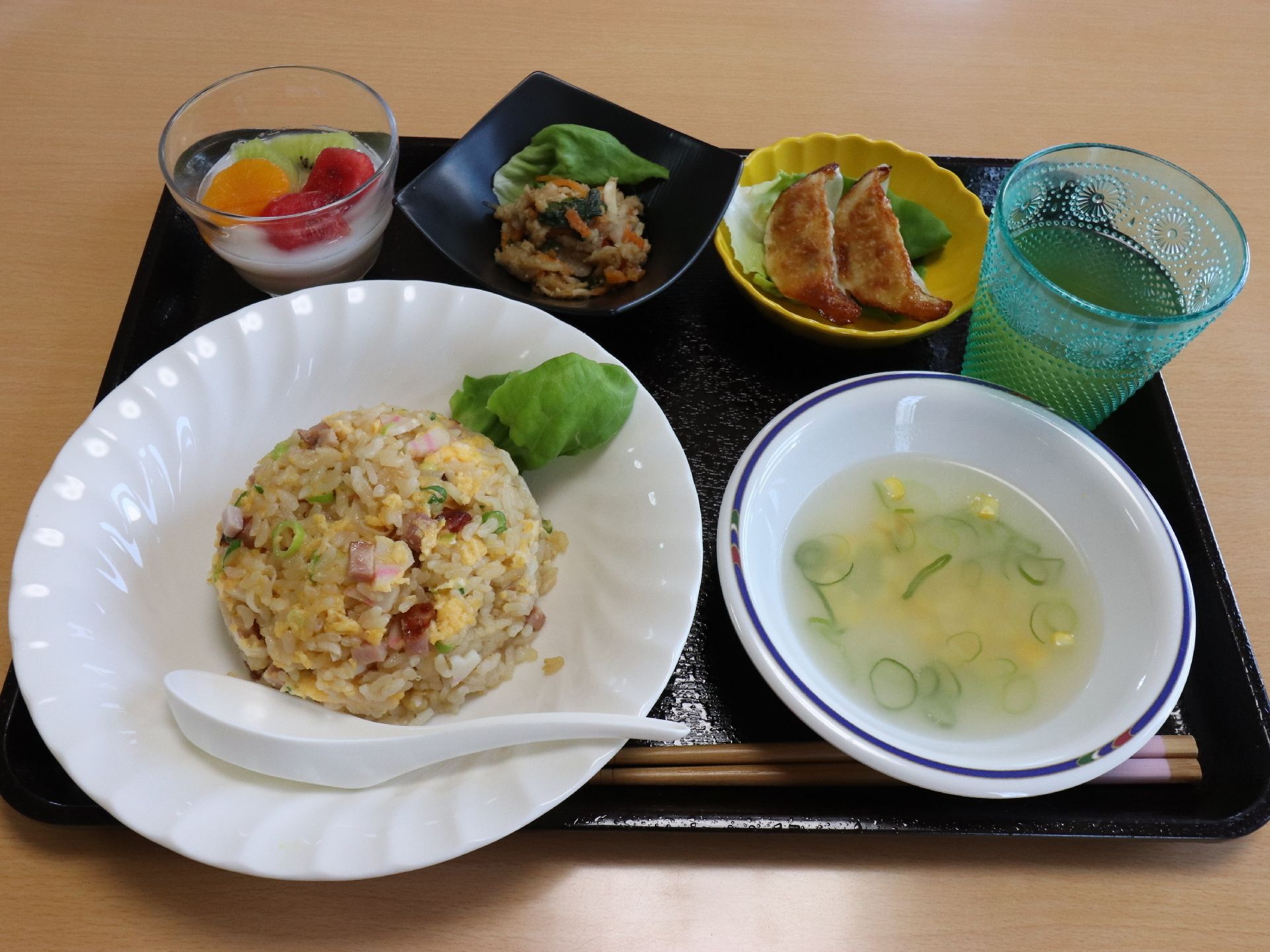 ある日の中華メニュー。チャーハンに餃子、和え物、スープ、杏仁豆腐、お茶が並べられている。ボリュームも満点。