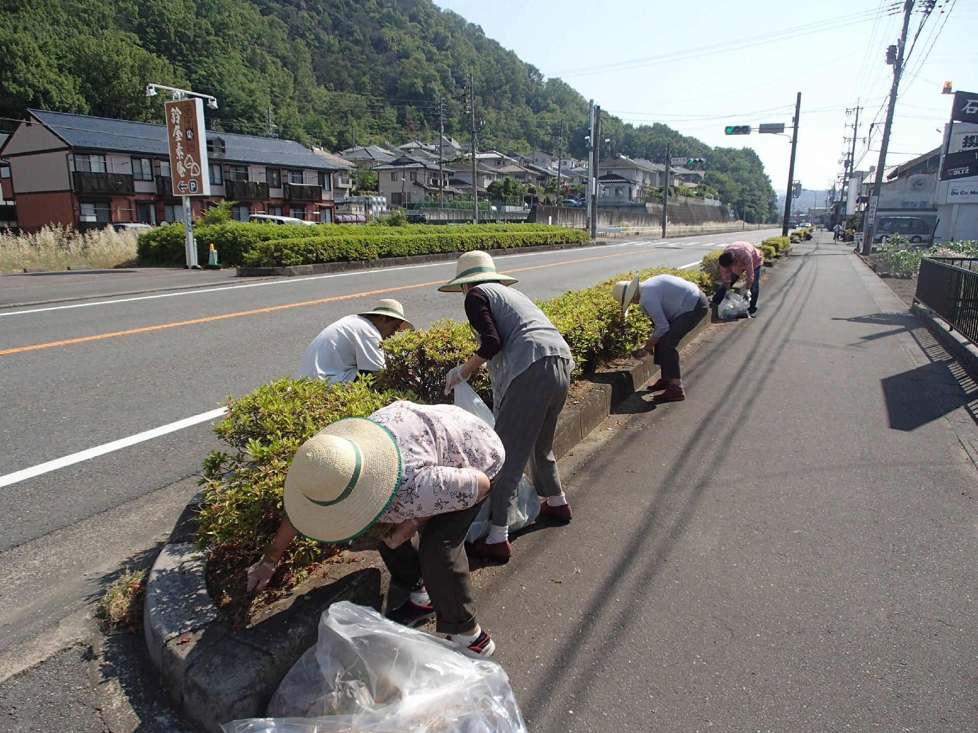 外の植木を手入れする人々