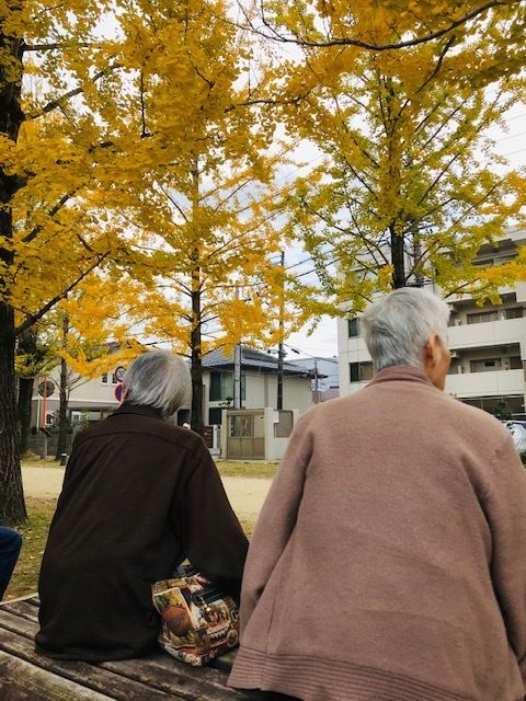 秋の日を楽しむ高齢者二人組