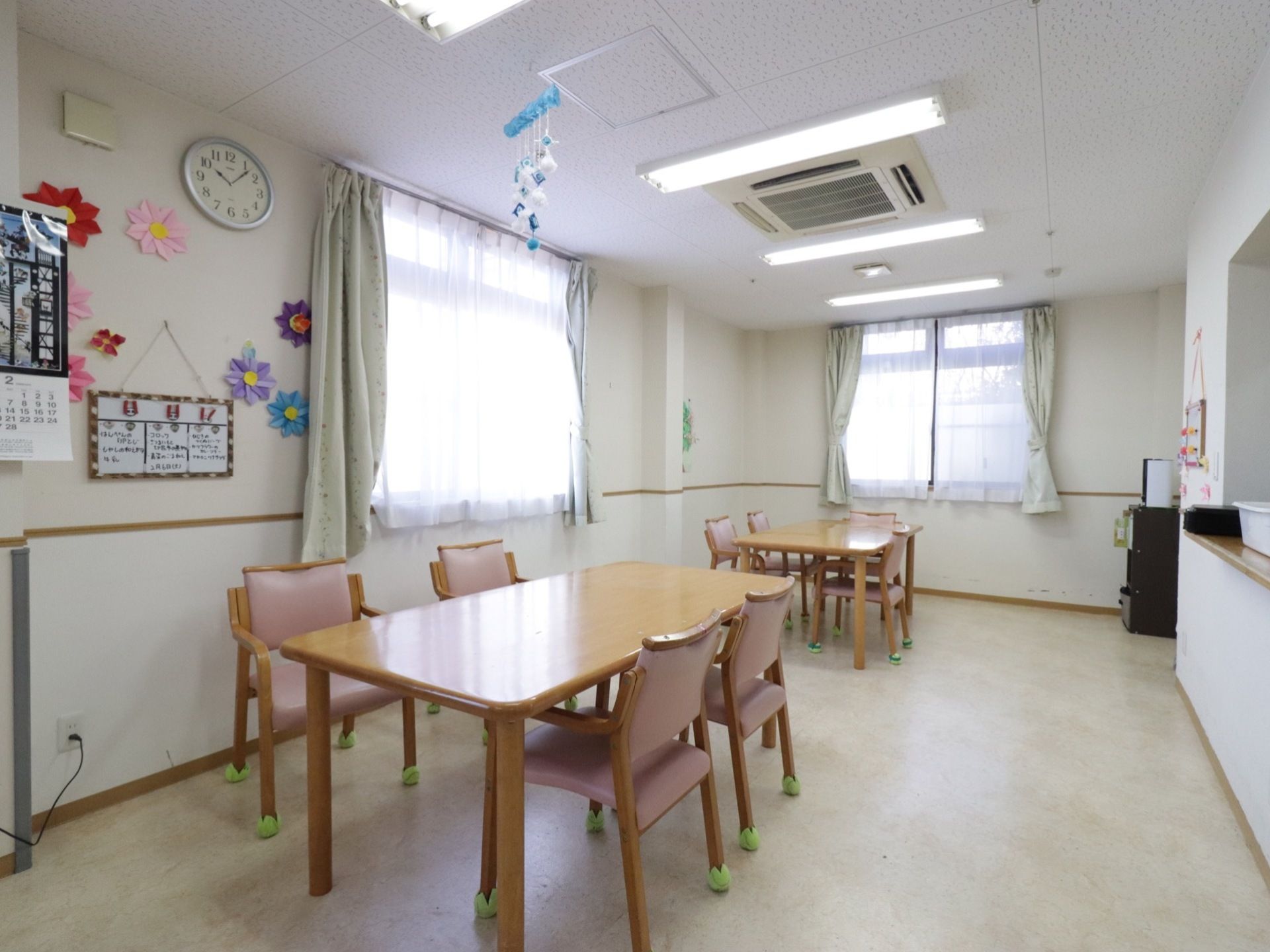 広々とした食堂には、対面式キッチンが設けられている。椅子がセットされたダイニングテーブルが並べられている。