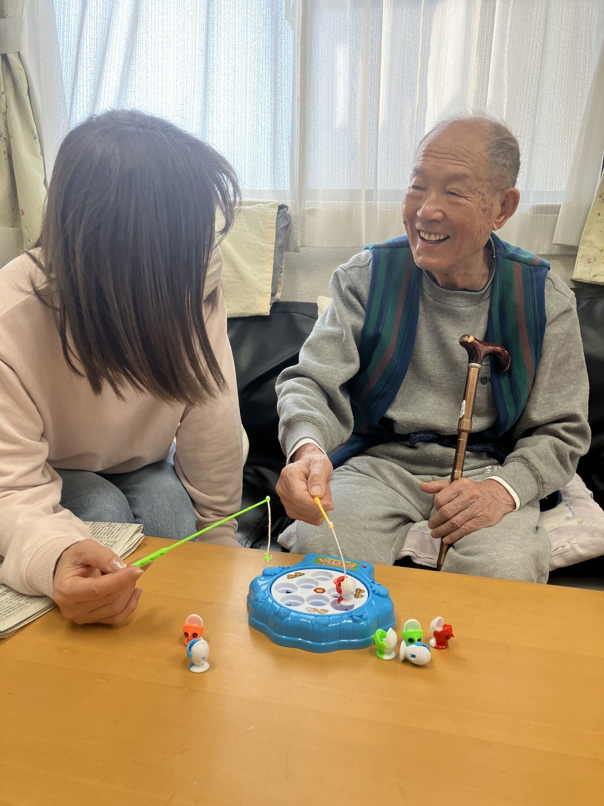 血圧測定中でも笑顔を絶やさないスタッフと談笑する入居者様