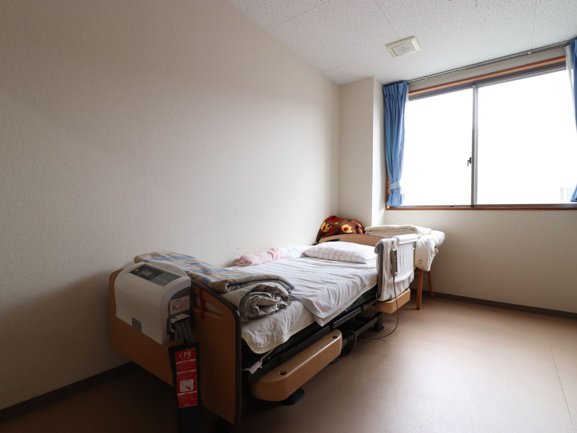 高い機能性が見て取れる、本格的な介護ベッド。ブラウンを基調としたカラーデザインが、居室の雰囲気とマッチしている。