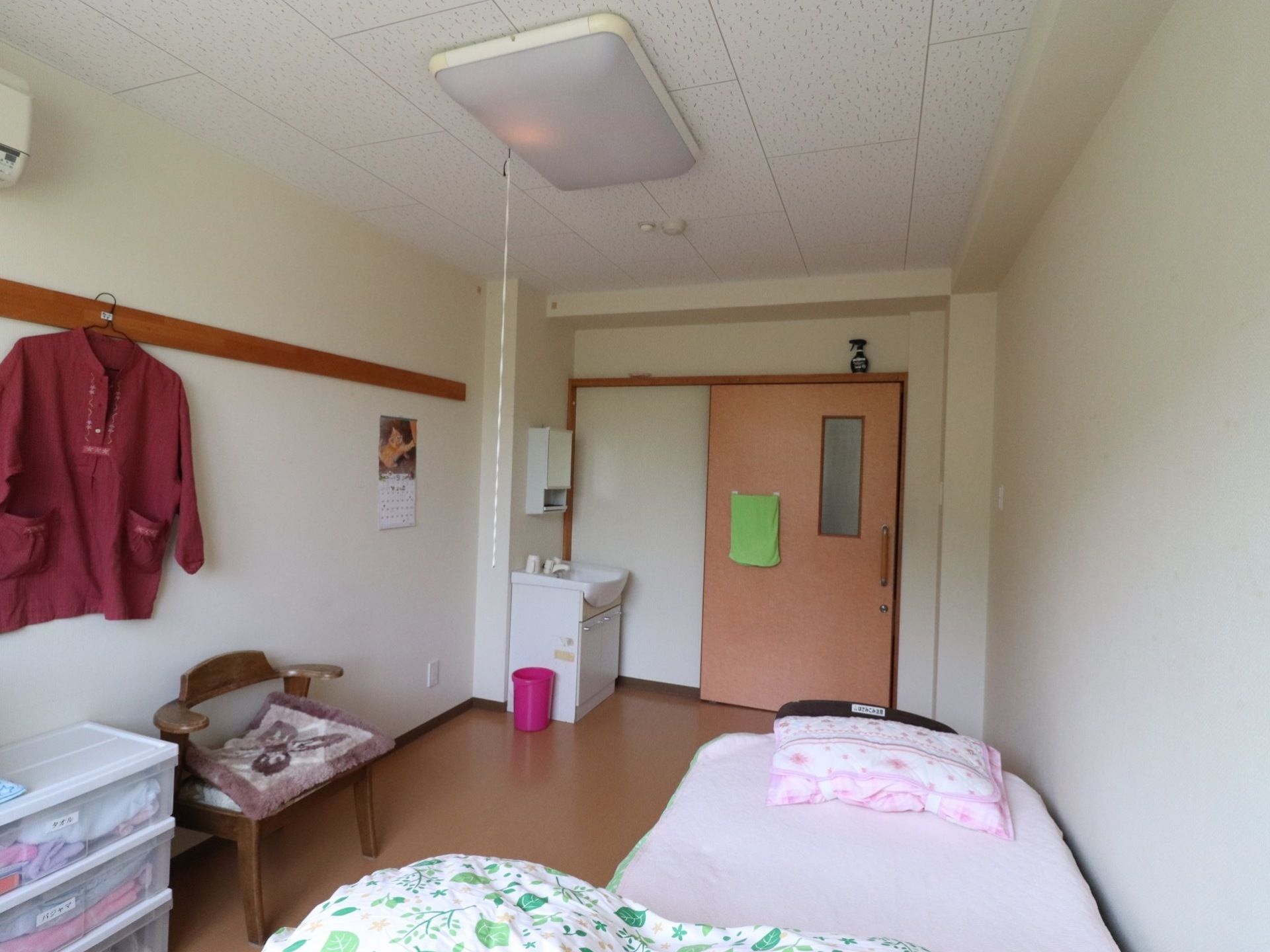 スライド式の扉となっている。扉の近くには洗面所が置かれている。スイッチ紐のある照明がつけられている。