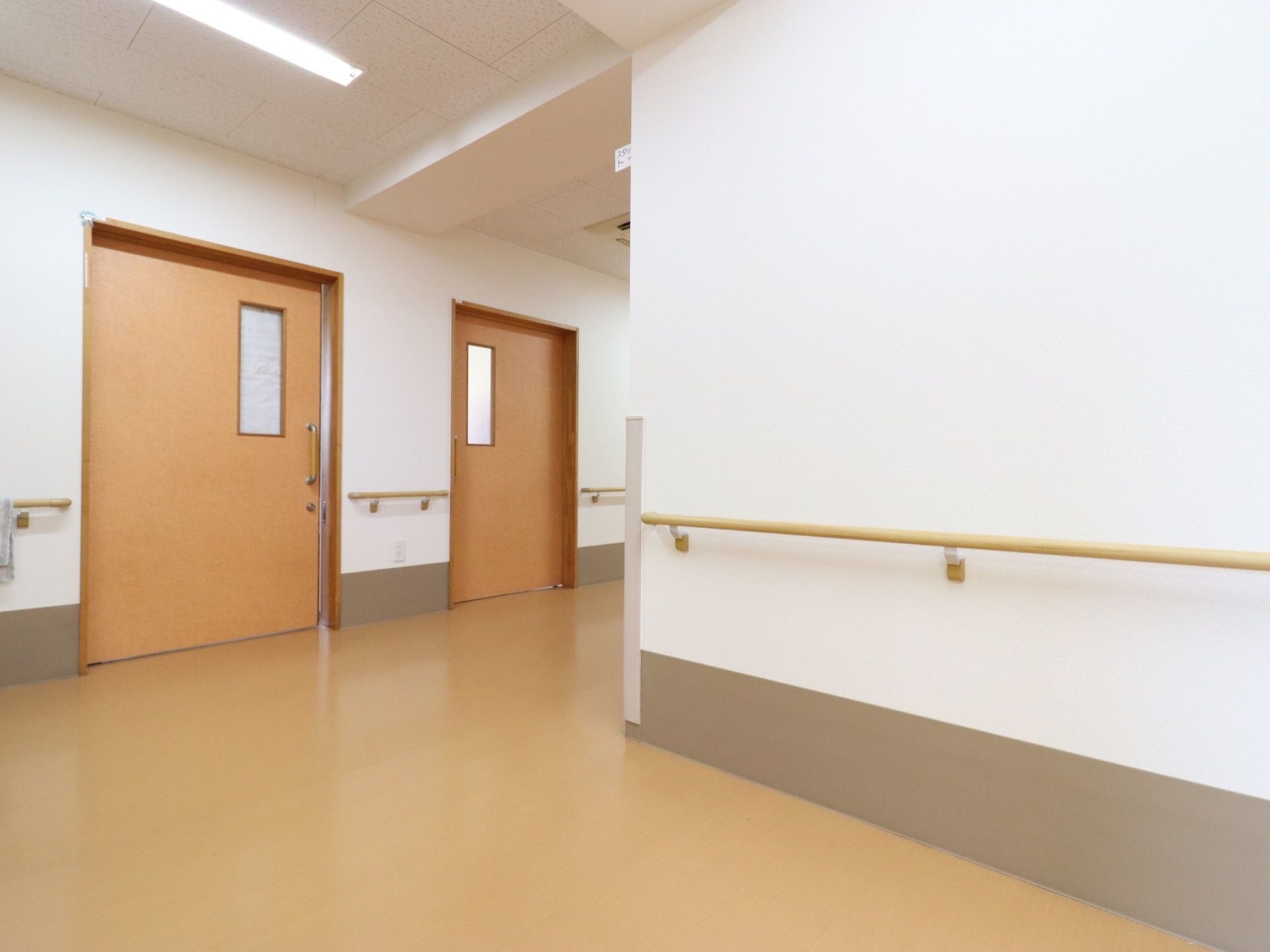 とても広い通路となっている。フラットな床なのでとても安全に移動することができます。手すりがあり、歩行をサポートする作りである。