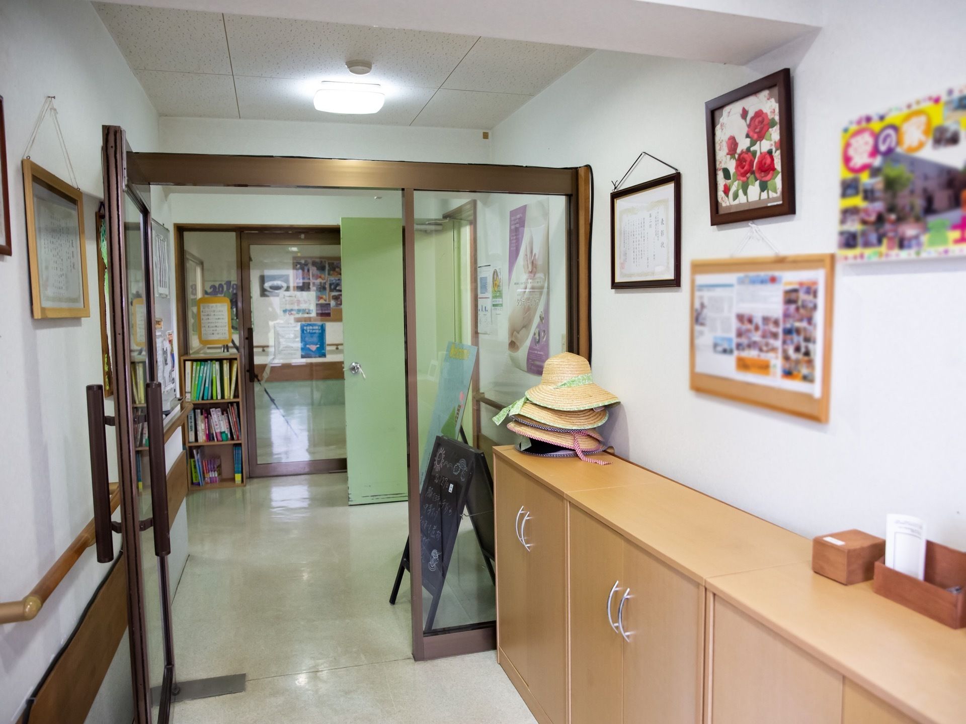 玄関の壁際には、靴箱が設置されている。手すりが壁に沿って設置されており、居住スペースへの扉はガラス張りの片開きドアになっている。