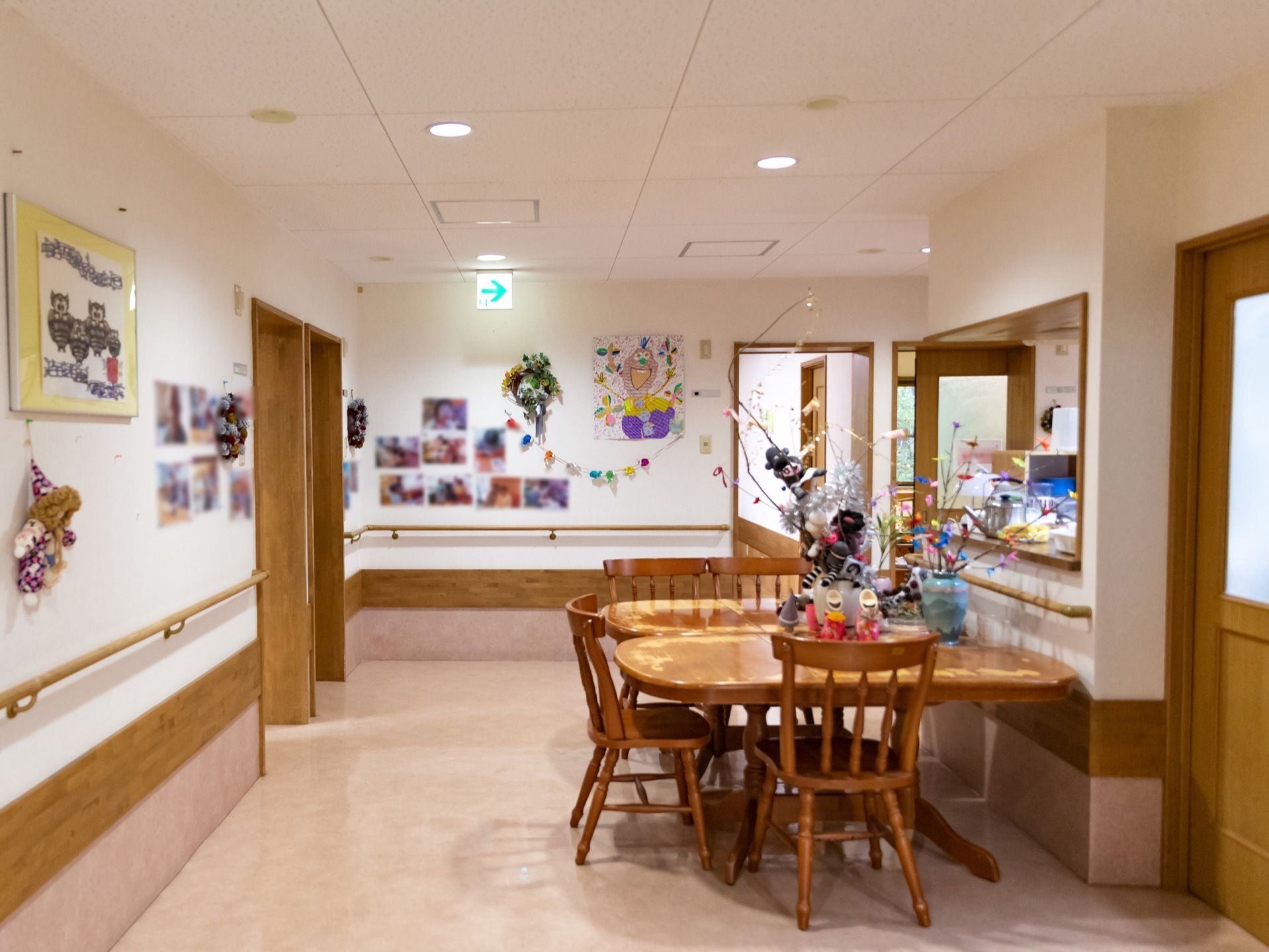 食堂は開放的な空間になっている。壁には写真や絵が飾られており、手すりが取りつけられている。椅子とダイニングテーブルが置かれている。