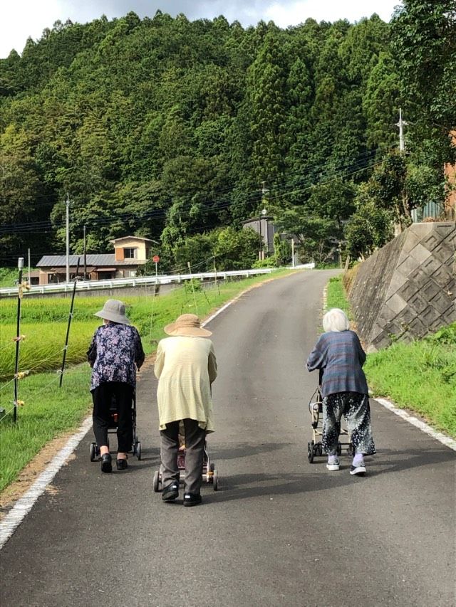 日本を代表する山を背景に並んで、写真に収まっている入居者様達とスタッフ