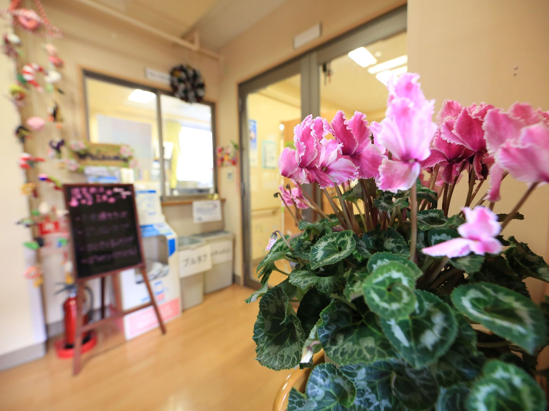 エントランスを入って受付付近に花が飾られている。装飾品もあり、華やかな雰囲気で皆様をお迎えしている。