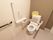背もたれ付きの手すりがトイレには備えられている。壁には手すりや緊急時呼び出しボタンが設置されている。