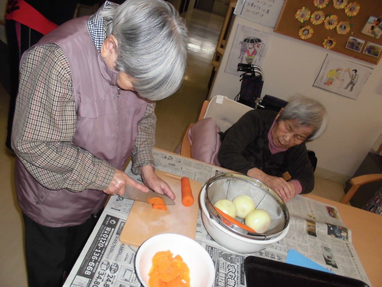 こたつでスタッフと一緒に、鍋を囲んでいる入居者様達