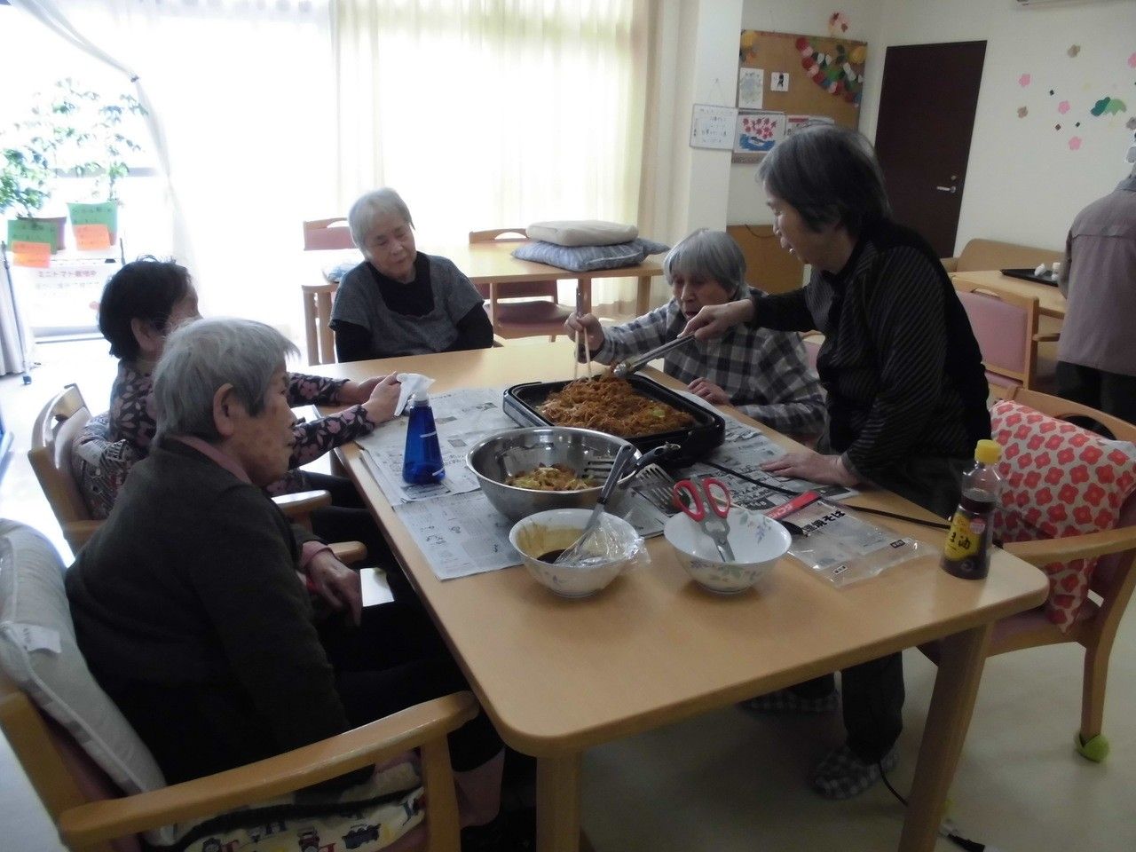 テーブルの中央にネットを立てて卓球を楽しんでいる女性入居者様