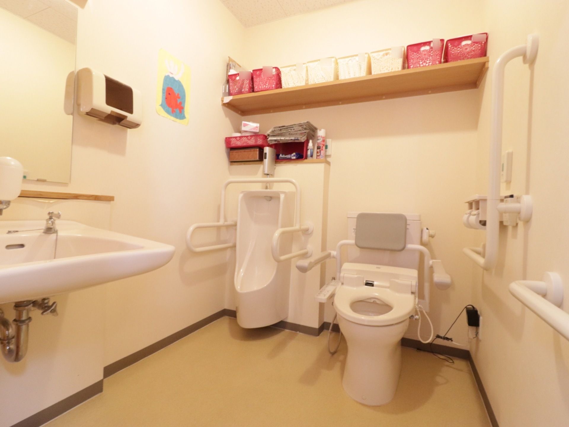 広々とした清潔感のあるトイレには、温水洗浄便座、男性用トイレ、手洗いスペースが完備されている。しっかりとした手すりも付いている。