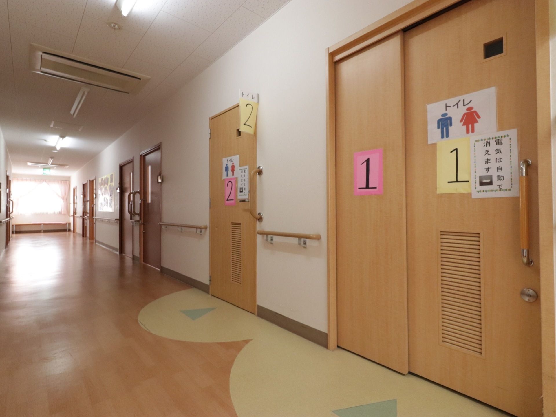 右側の壁にトイレへ続く入り口が設けられている。トイレは男女兼用になっている。入り口のスライド式ドアには数字の書かれた紙が貼られている。