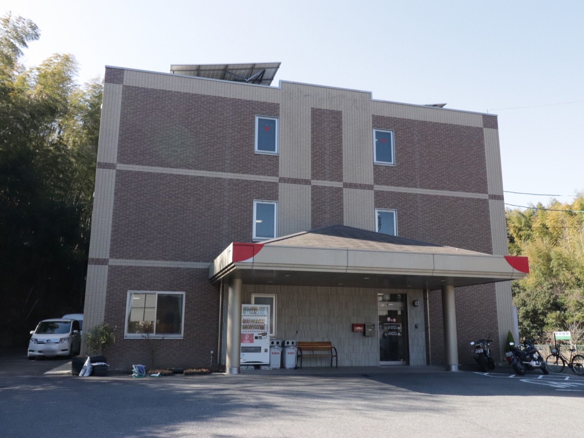 3階建てのダークブラウンを基調とした新しい建物である。エントランス前には自動販売機やベンチが置いてある。駐車場がすぐそばにあり便利である。