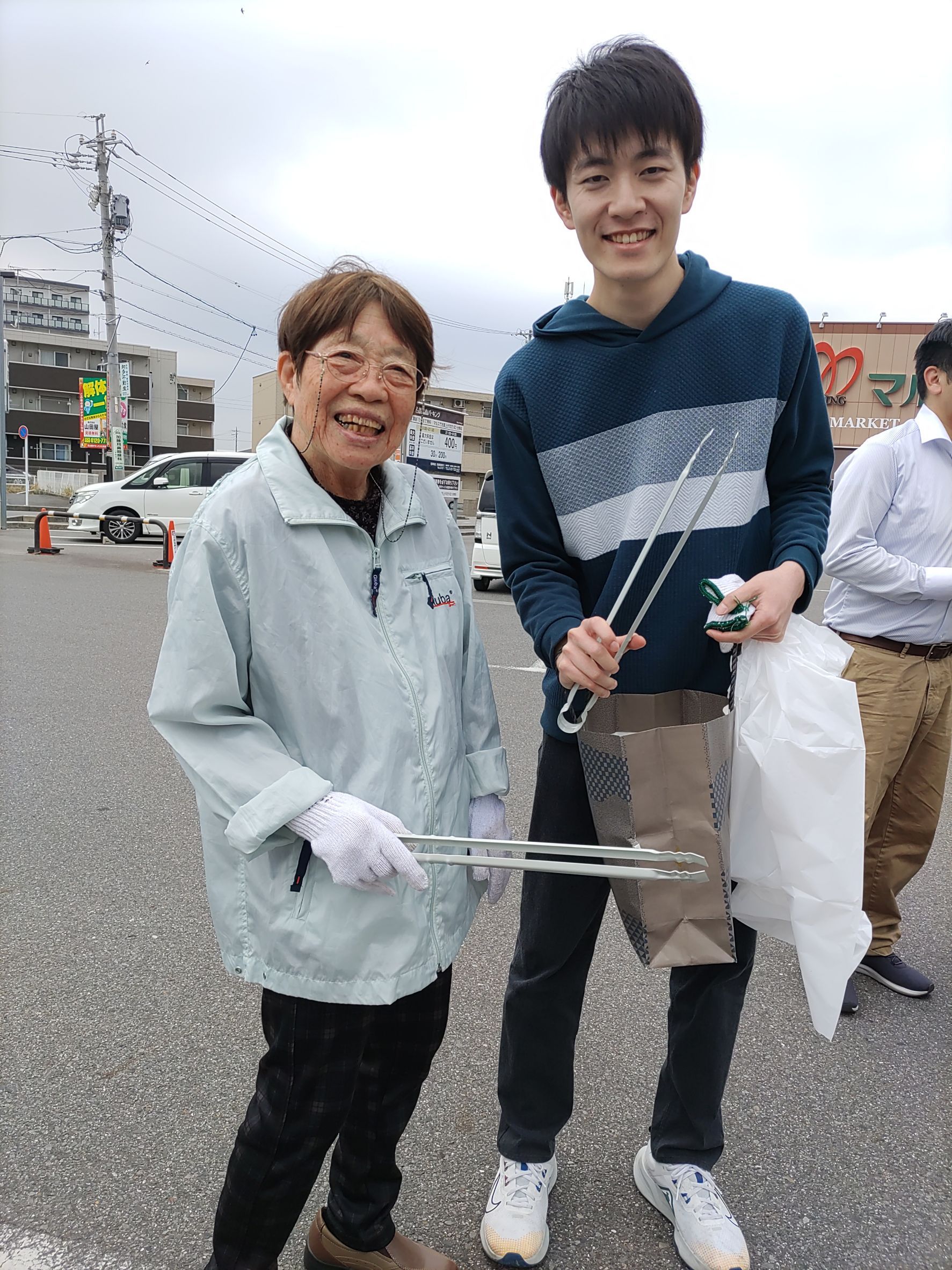 明るい共有スペースでギターや電子ピアノの演奏に合わせて歌を歌う女性ボランティア。