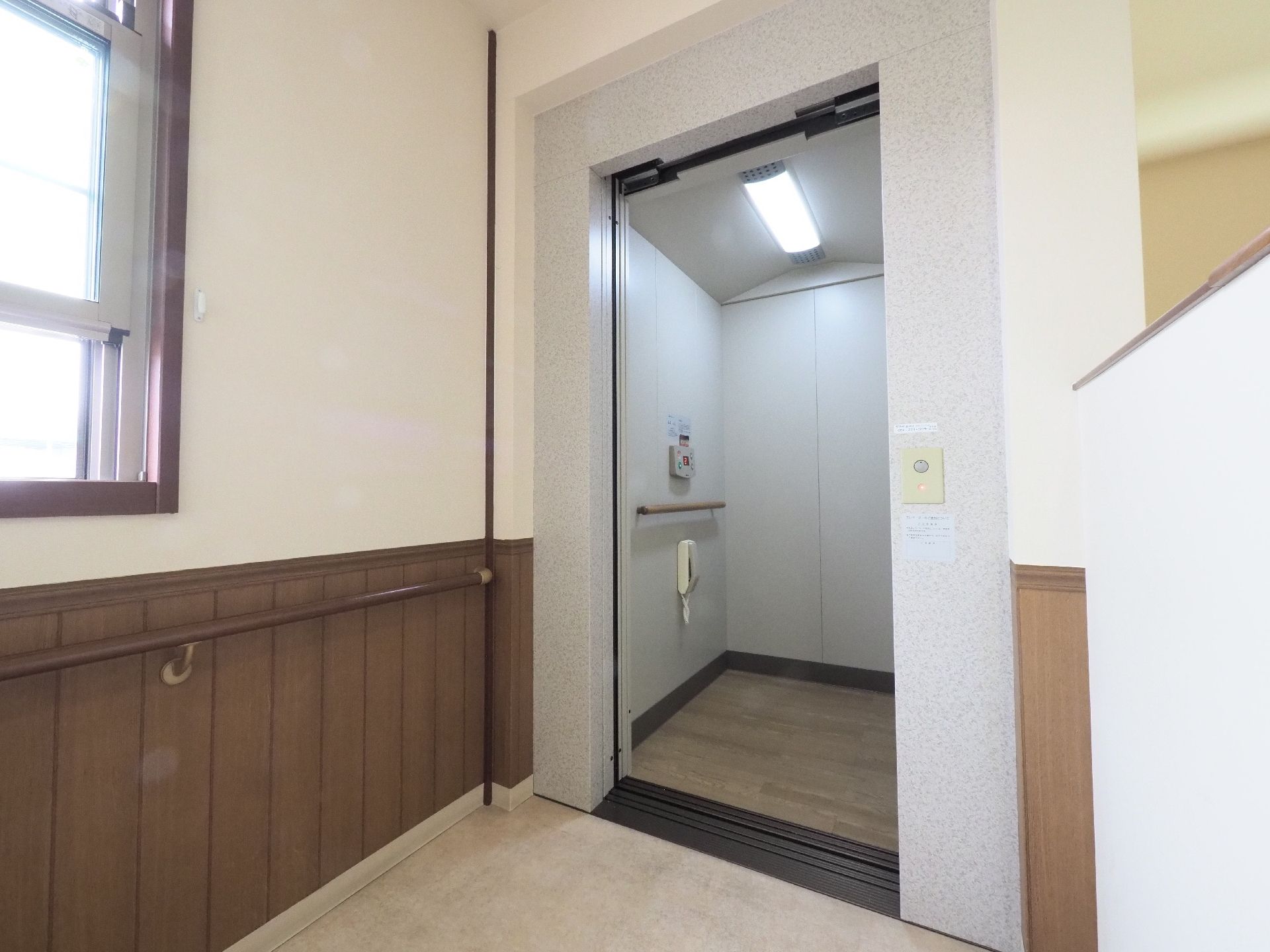 廊下には大理石風のデザインのエレベーターが設置されている。奥行きがあり壁は手すりのほか内線電話も設置されている。