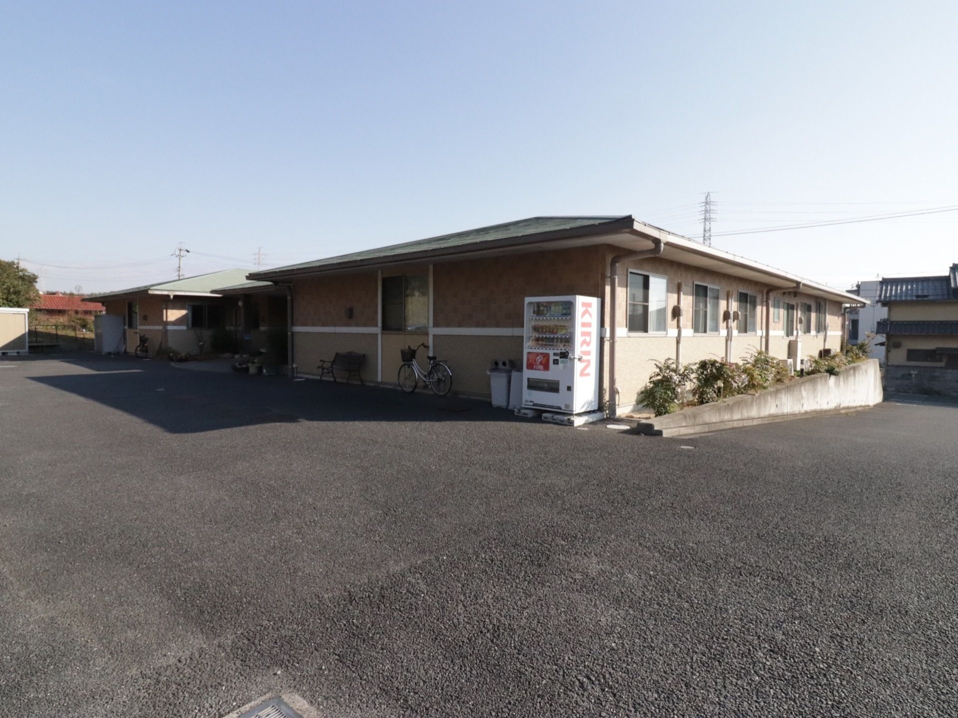 ブラウンを基調とした平屋の建物である。玄関外には自動販売機が設置されている。建物の周囲が広くとってあり車を置くスペースがある。