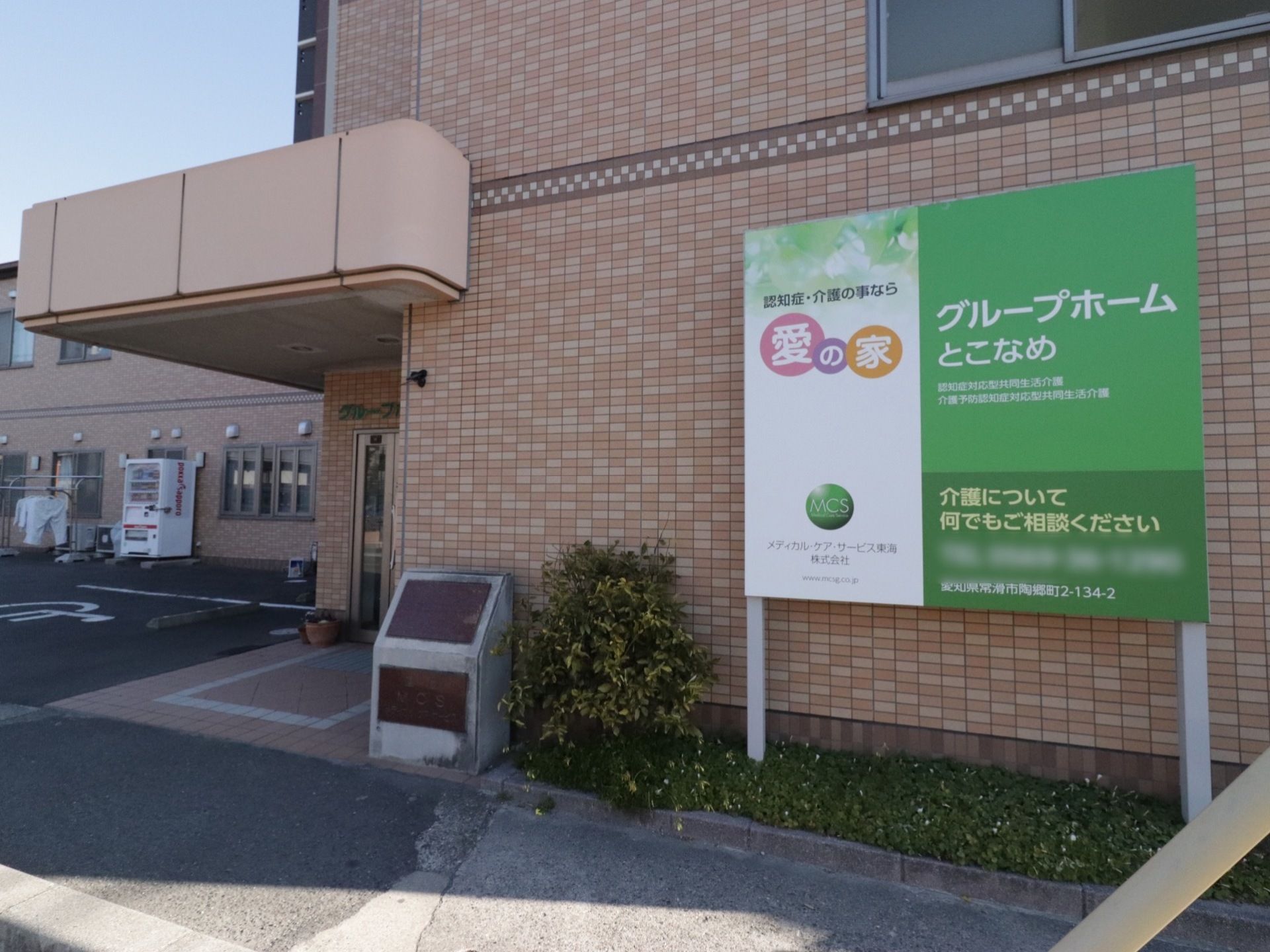 2階建てのダークブラウンを基調としたレンガ造りの建物である。植え込みには施設を宣伝した看板が立てられている。