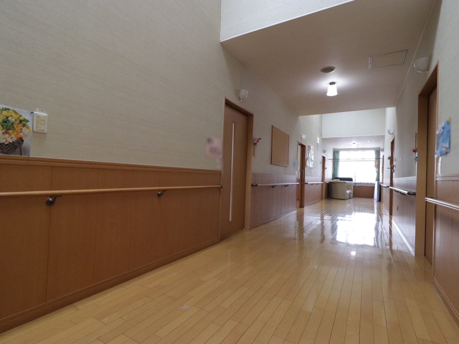 通路はナチュラルな色合いのフローリングとなっていて、ゆったり広々としている。フラットで十分な広さがあるので車椅子も楽に通れる。