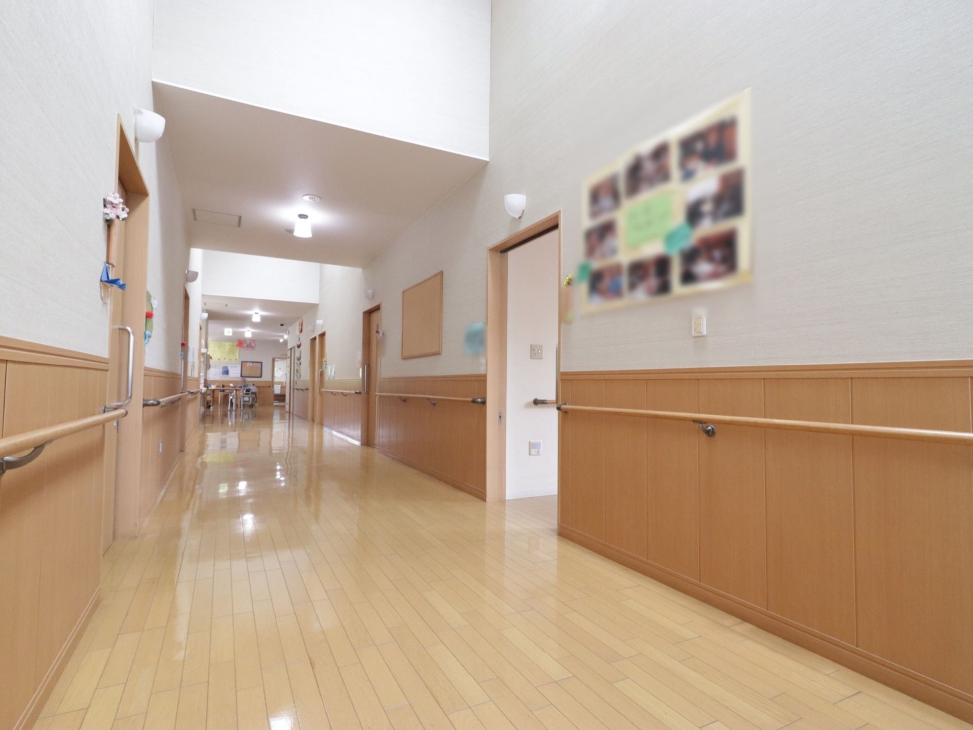 通路の壁には手すりが取り付けられているので、安心して通行できる。また、両側に各居室のドアが並んでいる。