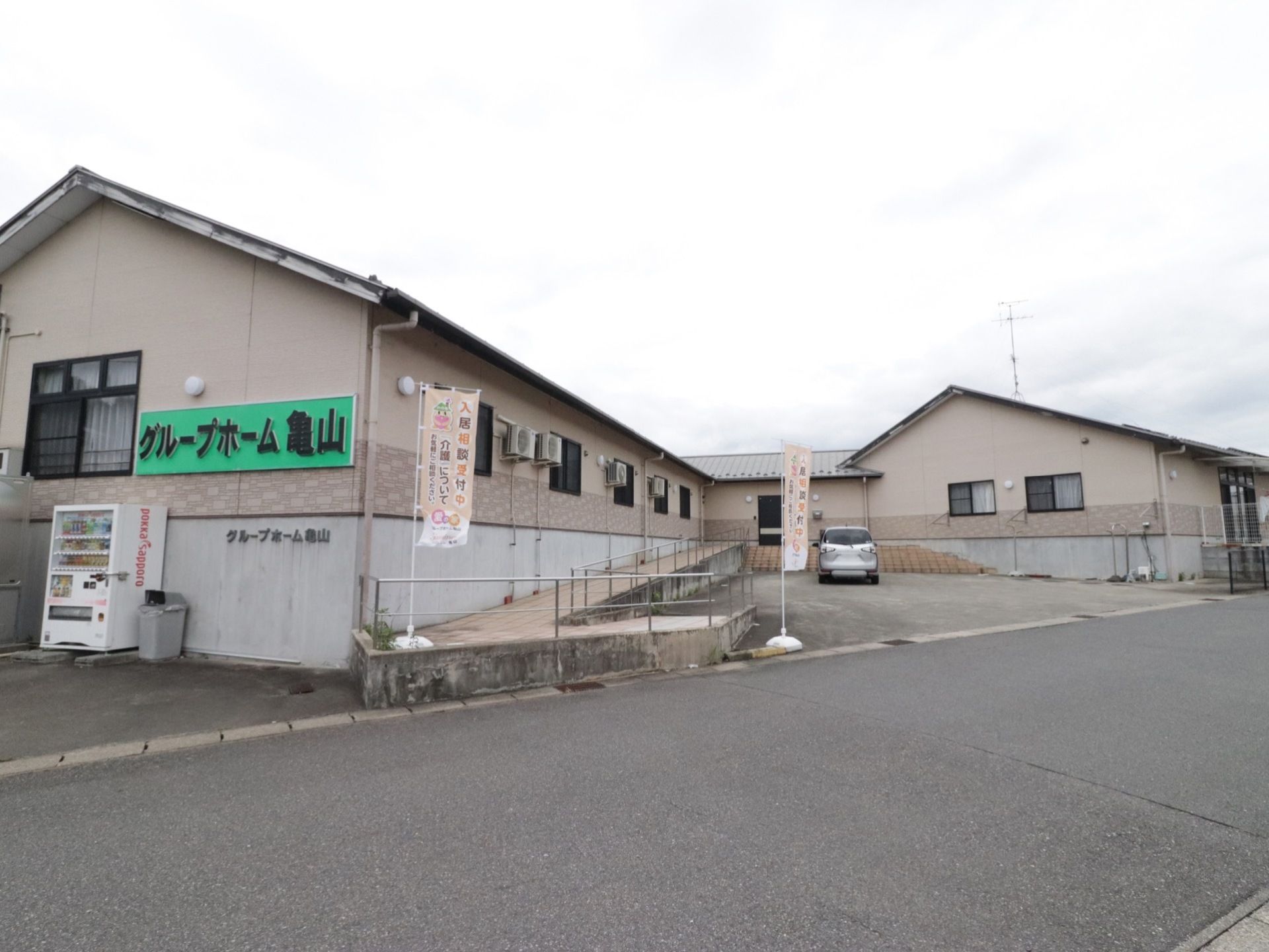 茶色の平屋の建物で、坂に沿ってコンクリートで土台を作っているため、道路に対して建物はやや高い場所にある。