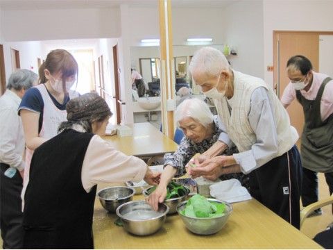 テーブルの上に置かれた食材を処理している入居者様達