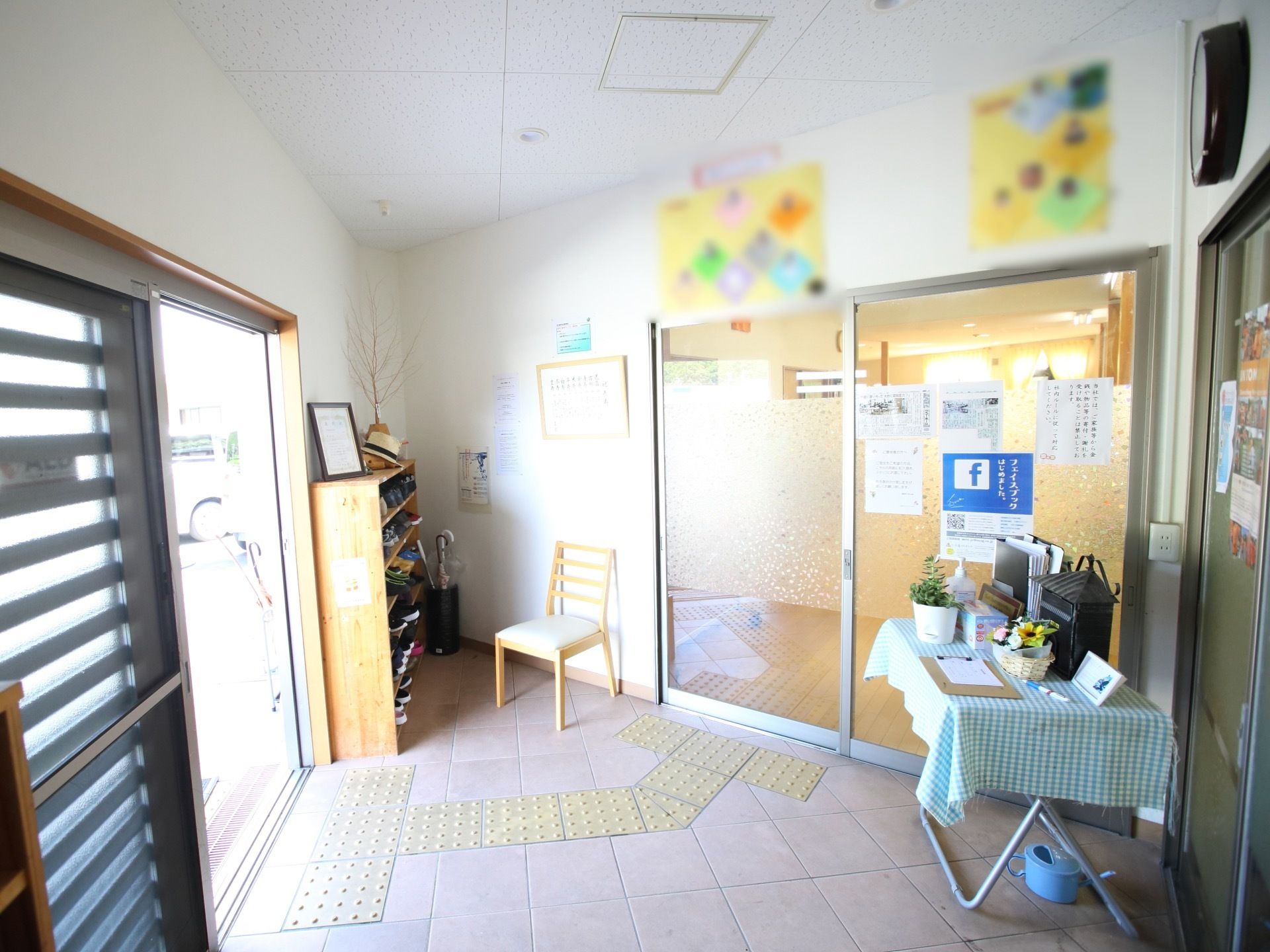 玄関の扉と居住空間などに通じる扉の中間にある玄関ホール。下駄箱と椅子が置かれていて、床には点字ブロックも設置されている。