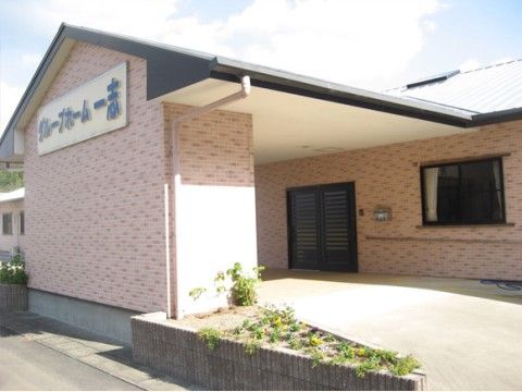 車寄せ前面の大きな壁に施設名称が表示されている施設外観