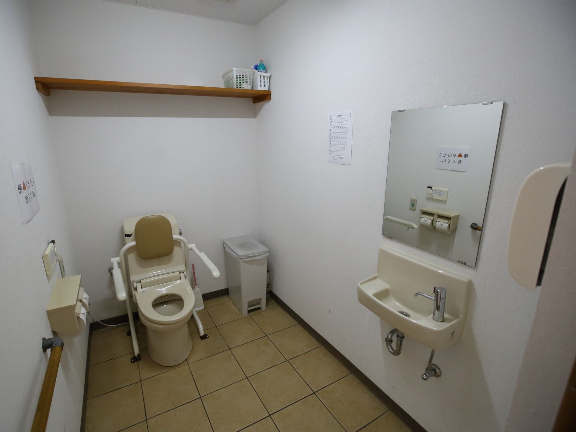 広々としたトイレには鏡のついた洗面台が備わっている。便座には手すりの他に背もたれがついており、体への負担を軽減してくれる。