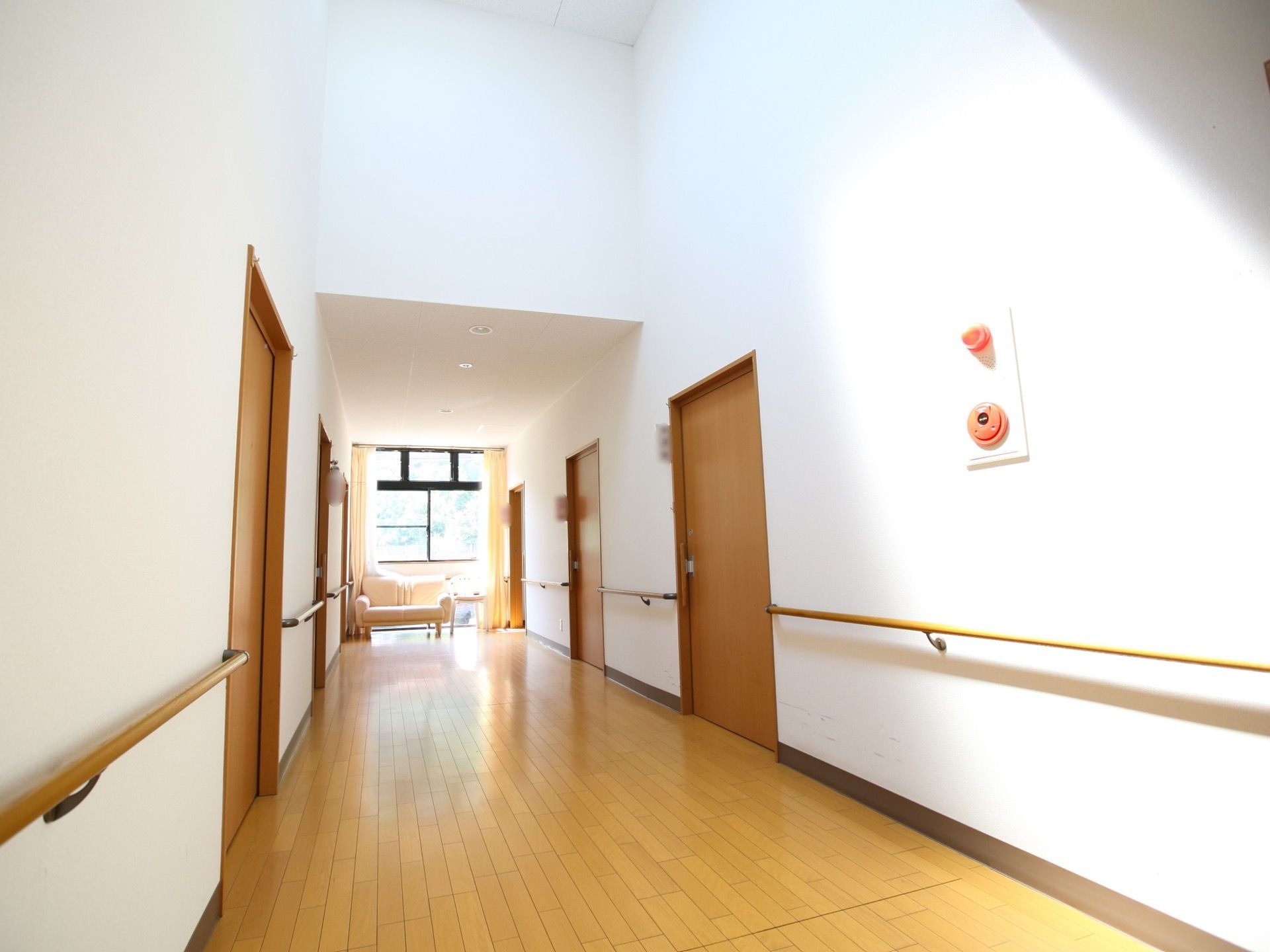 廊下は窓から日が差し込み、明るく開放的である。手すりが両側にあり、幅が広いのでスムーズに移動することができる。