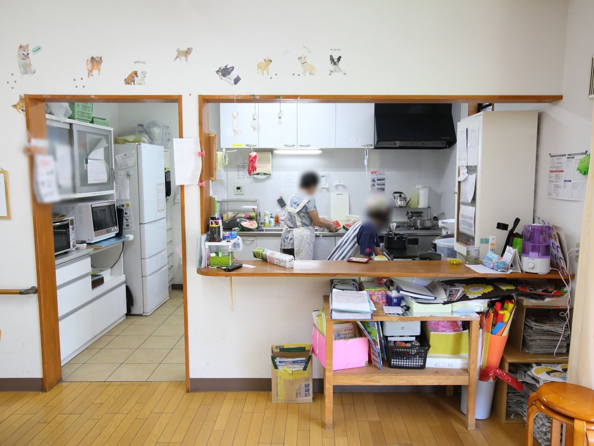 台所ではスタッフ２名が作業を行なっている。広々とした造りで、ゆったりと調理を行うことができる。たくさんの調理器具や道具が揃っている。