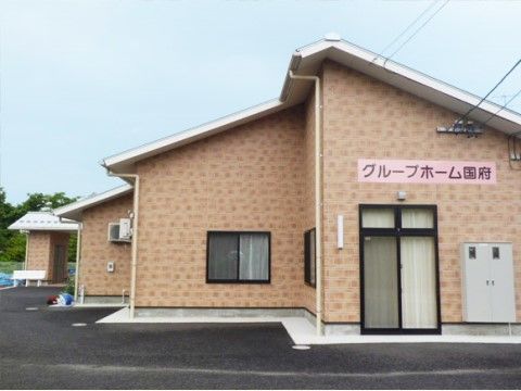 落ち着いた色調で統一された外壁を持つ平屋建ての施設外観