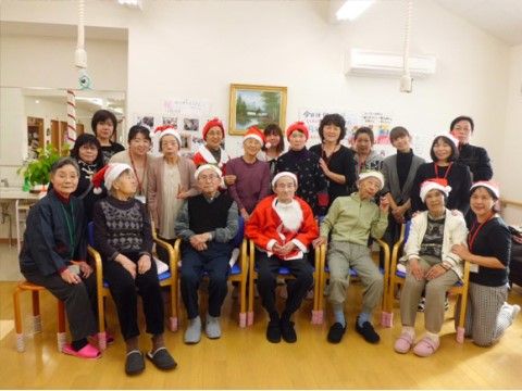 季節のイベントにちなんだ帽子をかぶって集合写真に収まる入居者様とスタッフ