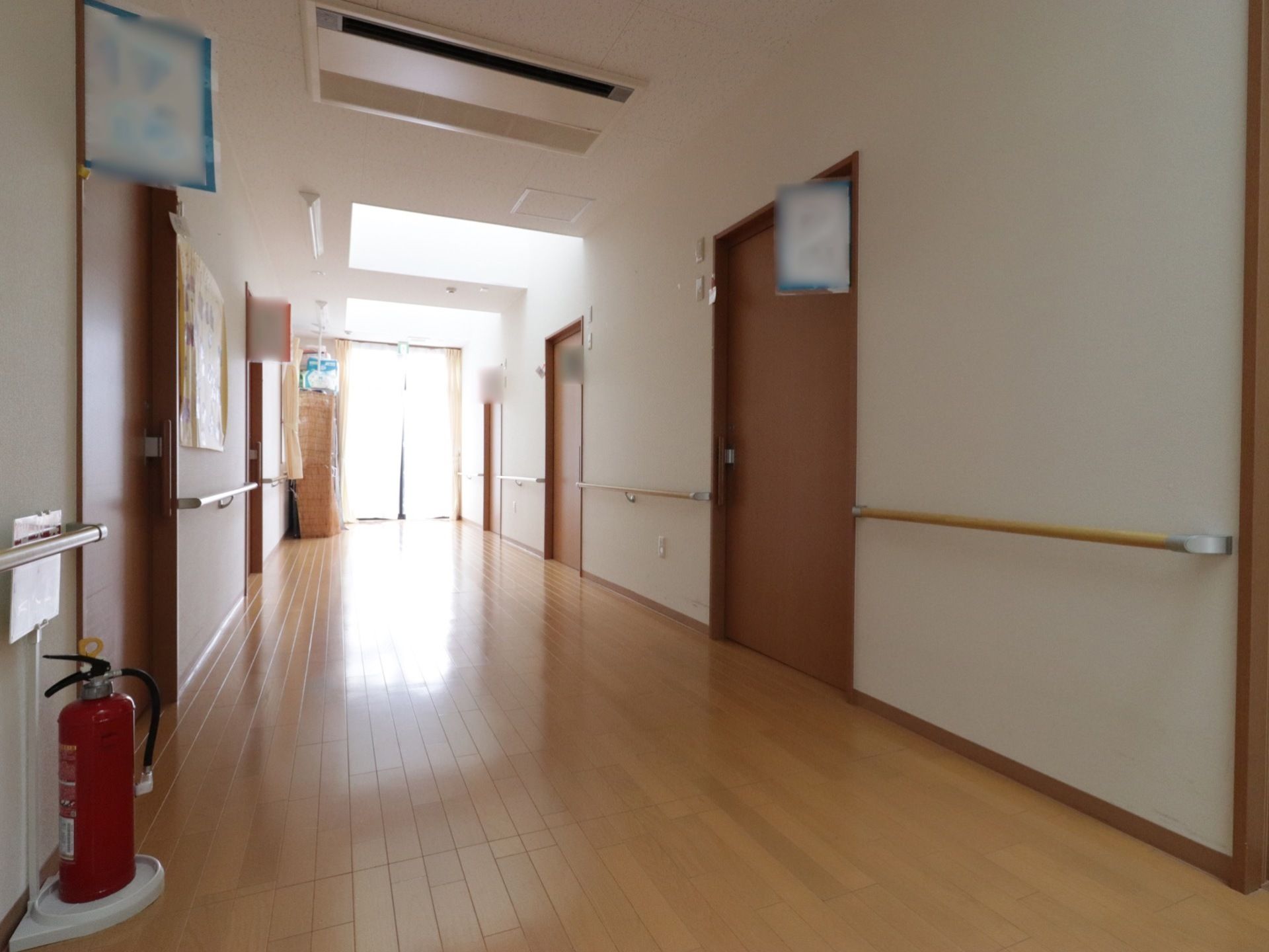 通路はフローリング張りで、ゆったり広々としている。壁には手すりが設置されているので安全に移動できる。