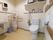 洗面台、男性用トイレ、洋式トイレがあるトイレで、使い捨てのペーパータオルディスペンサーが壁につけてある。