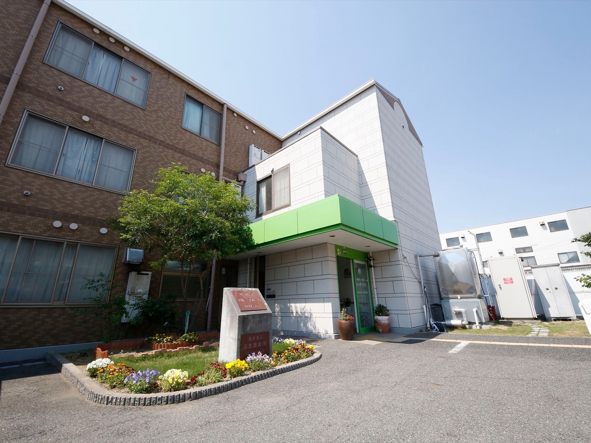広々とした駐車場から玄関まで段差なく移動できる。居住区間と玄関は外壁がそれぞれ茶系と白で色分けされており、視覚的にわかりやすい。
