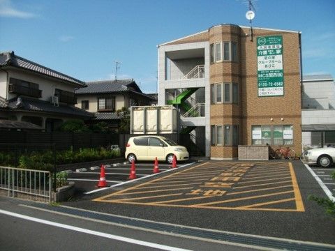 敷地内に白線で仕切られた多くの駐車スペースがある施設外観